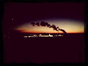 Silhouette trees against sky at night