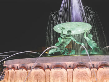 Close-up of illuminated sculpture against black background