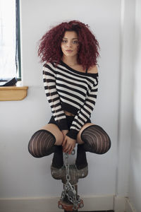 Young woman crouching on a chained appliance