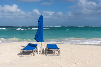 Lifeguard chair on beach against sky