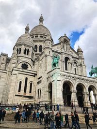 Group of people in front of building against sky