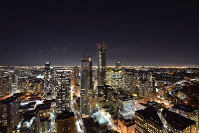 Illuminated cityscape against sky at night