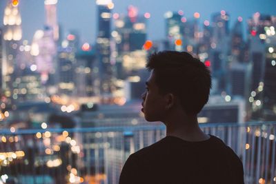 Woman in illuminated city at night