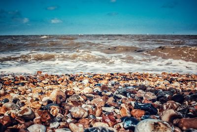 Pebbles on beach against sky