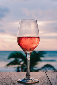 Close-up of drink on table next to the beach