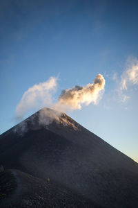 Low angle view of volcanic mountain against sky