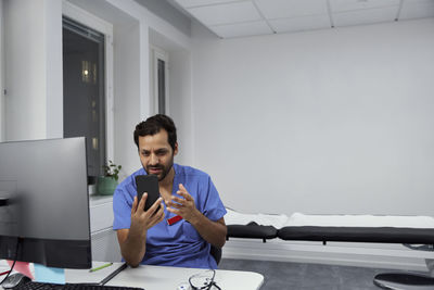 Male doctor having online consultation on smart phone