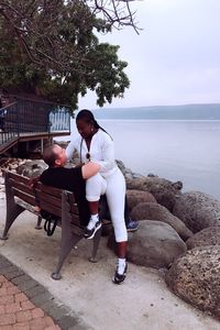 Full length of young woman on shore against sky