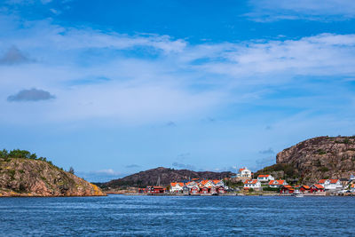 Scenic view of sea by buildings against sky