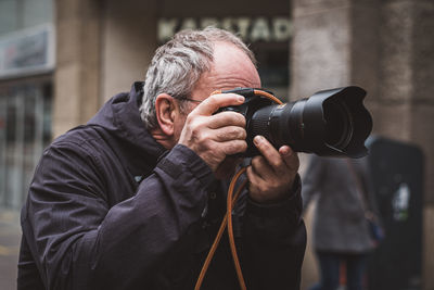 Man photographing while standing in city