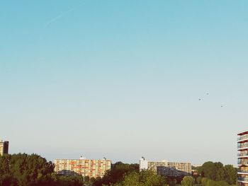 View of cityscape against clear blue sky