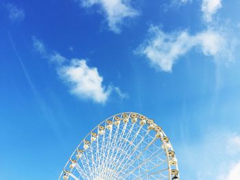 Low angle view of ferris wheel against blue sky