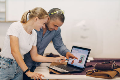 Side view of man using laptop at office