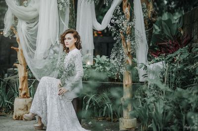 Young woman standing by plants