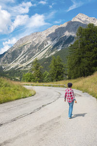 Rear view of woman walking on road