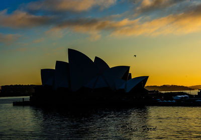 Silhouette city against sky during sunset