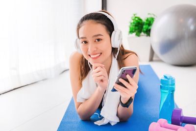 Portrait of smiling girl using mobile phone at home