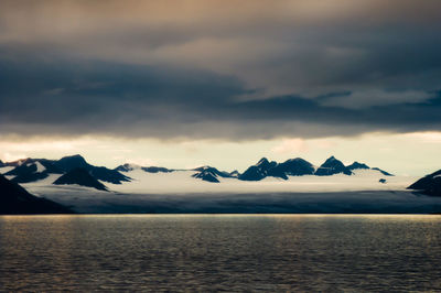 Scenic view of sea and mountains against sky during sunset