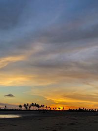 Scenic view of sea against dramatic sky during sunset