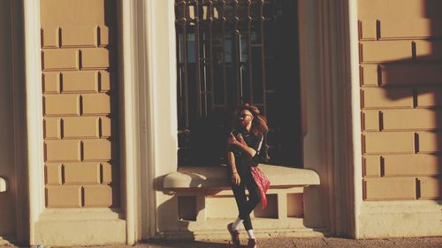 Full length of woman standing against building