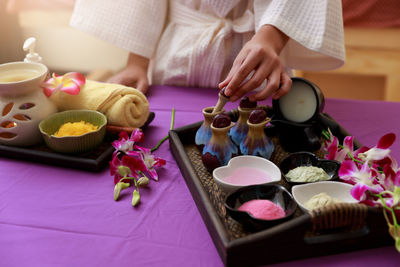 Midsection of woman with spa equipment on table at spa