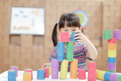 Close-up of girl stacking multi colored toys