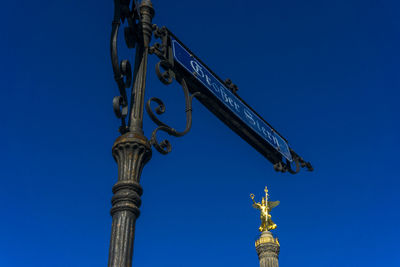 Low angle view of grosser stern sign and victory column against clear blue sky