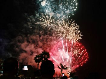 People watching firework display at night