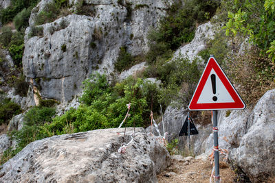 Road sign by rock