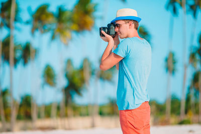 Man photographing with umbrella standing outdoors