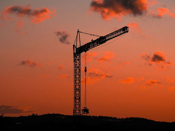 Cranes at construction site during sunset