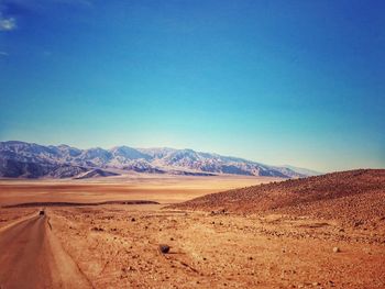 Scenic view of desert against clear blue sky