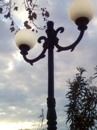 Low angle view of street light against cloudy sky