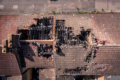 Aerial view above a row of burnt out and derelict terraced houses with roof damage after house fire