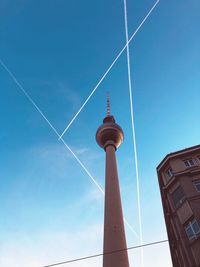 Low angle view of communications tower against blue sky