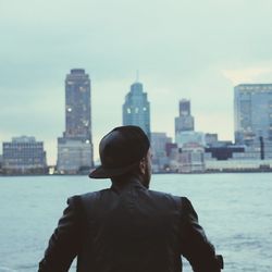 Rear view of man standing against cityscape