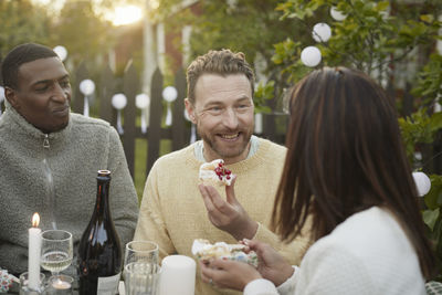 Smiling men talking at garden party