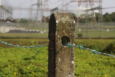 Close-up of barbed wire fence on field