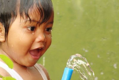 Close-up portrait of cute boy drinking water