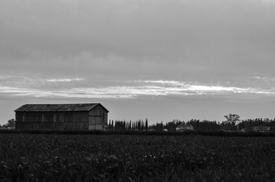 Barn on field against sky