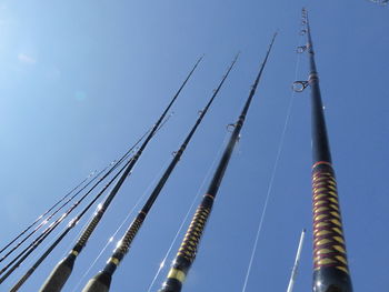 Low angle view of poles against clear sky