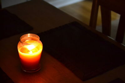 Close-up of illuminated tea light candle on table