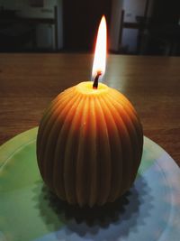 Close-up of lit candle on table