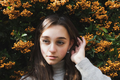 Portrait of beautiful woman with red flowers