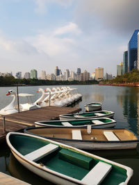Boats moored at harbor against buildings in city