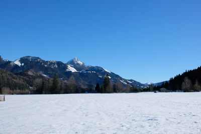 Scenic view of snowcapped mountains against clear blue sky