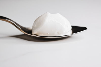 Close-up of ice cream in plate against white background