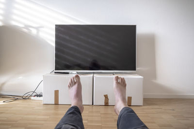 Low section of man relaxing on floor at home