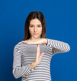 Portrait of a smiling young woman against blue background