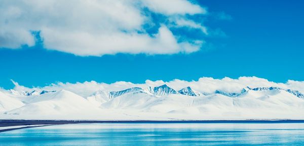 Scenic view of sea and mountains against sky